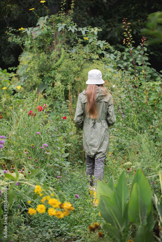 Woman walking alone through green garden path for wellbeing concept