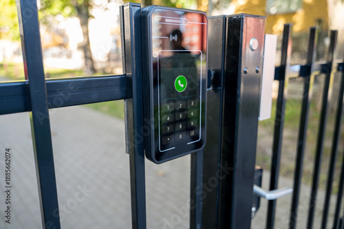 Smart intercom with face recognition is installed on gate leading to home territory. Modern access control system emphasizes security automation and smart home technology