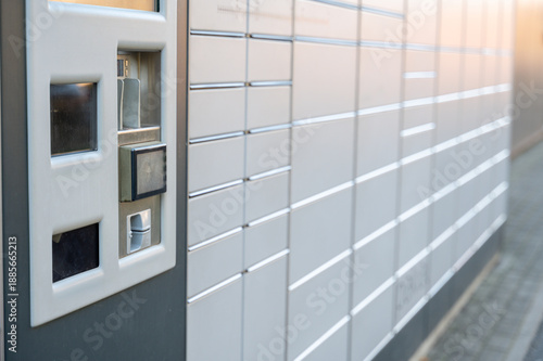 Parcel locker station with service terminal in foreground and rows of lockers behind
