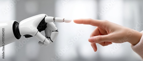 A robot hand and a human finger extend towards each other in a simple setting with bright light and a clear background