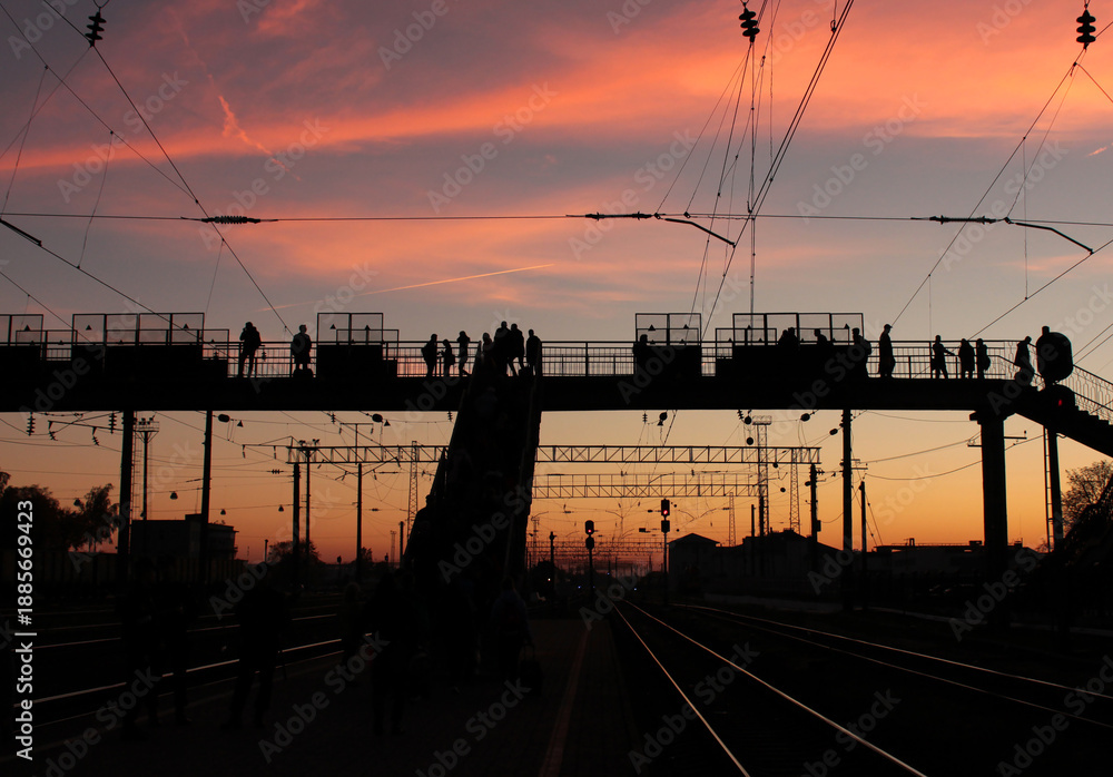 Naklejka premium This photograph captures a dramatic urban moment at dusk, where human presence, infrastructure, and sky meet in a striking balance