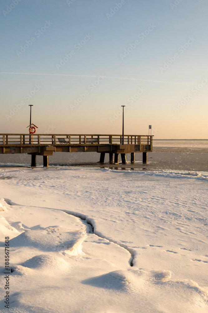 Fototapeta premium Wooden pier and frozen Baltic sea in Kuznica. Winter landscape on Hel Peninsula. Poland, Europe