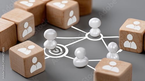 Wooden cubes display human icons and a target icon on a grey surface representing a business network concept in a top view layout