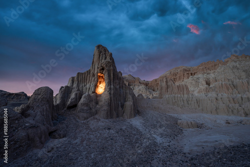 Dark storm clouds over an illuminated rock cave in Cathedral Gorge State Park Nevada 