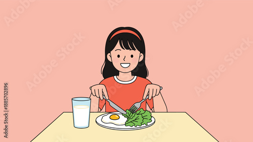Happy young girl sitting at a table and using a fork and knife to eat a healthy breakfast of fried egg and green lettuce.