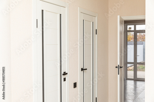 Wallpaper Mural Modern hallway with multiple white doors and light-colored walls, featuring a clean and minimalistic design aesthetic in a residential house. Real estate and renovation concept Torontodigital.ca