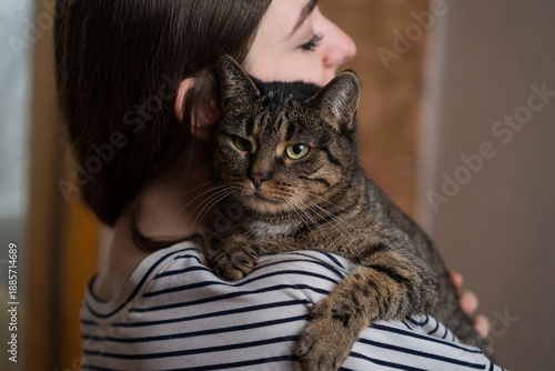 Close-up of a young сaucasian woman hugging a cute, friendly, fluffy domestic cat. Pet, animal.