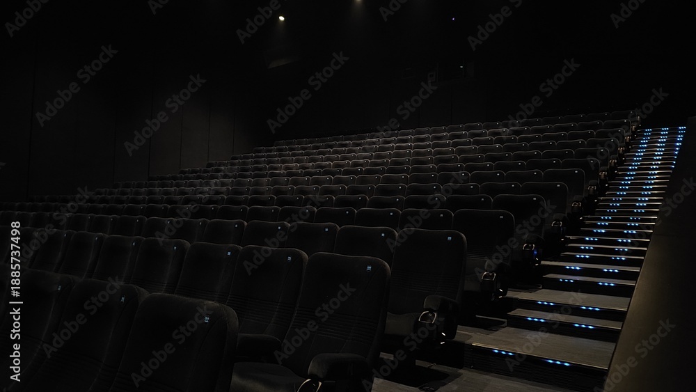 Obraz premium Empty cinema with rows of seats for film industry, movie theater websites, blog posts, or movierelated designs emphasizing solitude.