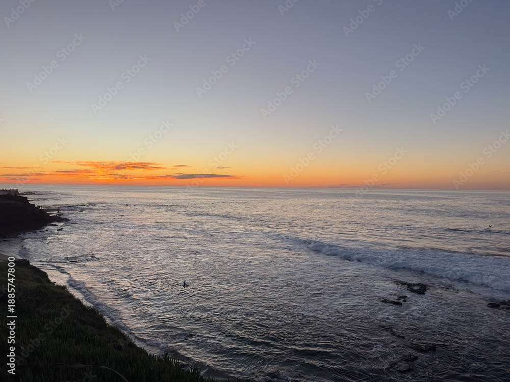 Fototapeta premium A beautiful and peaceful sunset casting warm light over the Pacific Coast in La Jolla, San Diego.