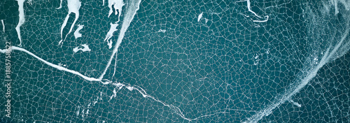 Photos Aerial view of cracked ice on dark blue lake water