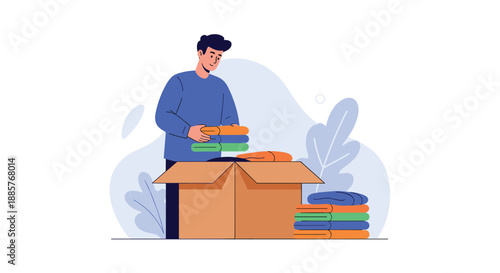 Young man carefully folding clothes and packing them into a cardboard box for donation, charity, or for moving to a new home.