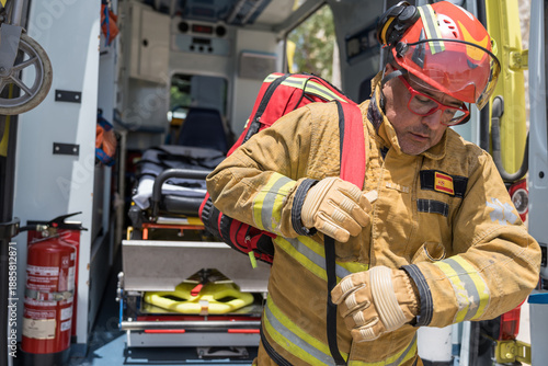 Bild auf Leinwand Firefighter wearing protective gear putting backpack in fire engine