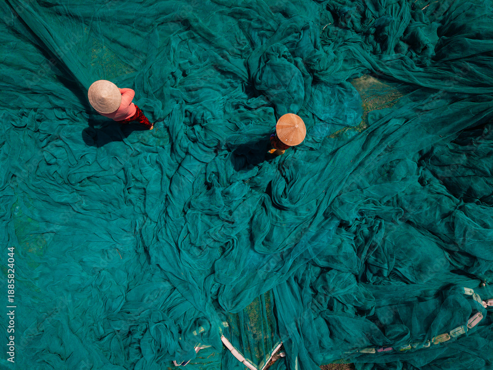 Fototapeta premium Aerial view of woman vietnamese fishermen with green fishing nets
