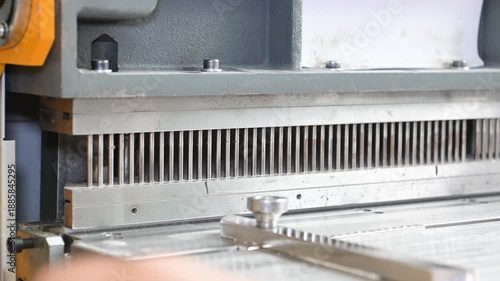 Women's hands in the printing house work at the machine, making holes in the paper to insert the spring for the notebook. Production of calendars and brochures