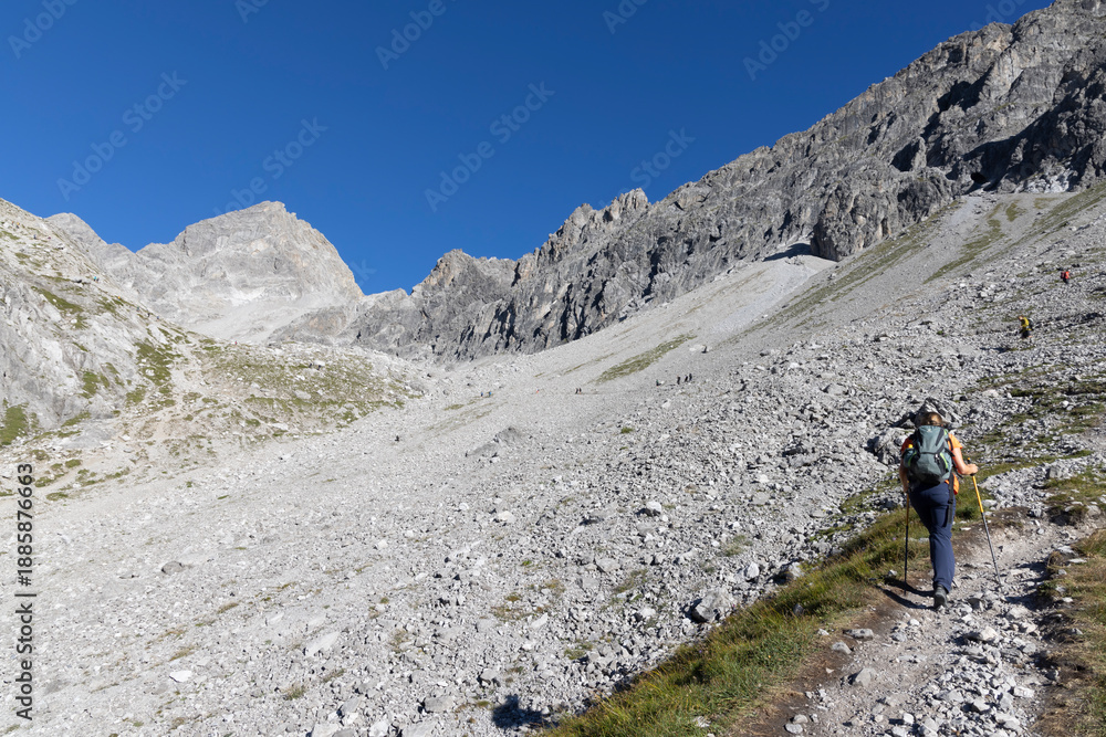 Fototapeta premium Hikers on the trail to Schesaplana in Vorarlberg Austria during a sunny day in the Ratikon mountain range