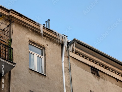Icicles Hanging from old Apartment Building Roof in Winter