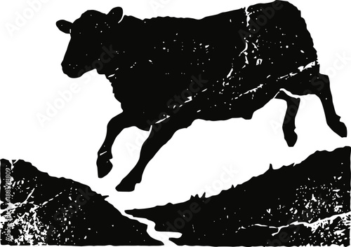 Black silhouette of a jumping cow over a river valley with a textured vintage