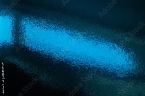 A vivid blue abstract background showing a glossy, textured surface reflectin...