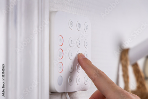 Détail en gros plan d'une personne tapant le code d'une alarme.