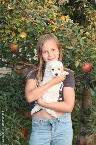 Young girl posing with Maltipoo puppy. Girl loving her pet.Stylish girl with dog