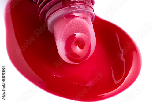 Fotografie Vivid crimson lip gloss application from tube applicator macro