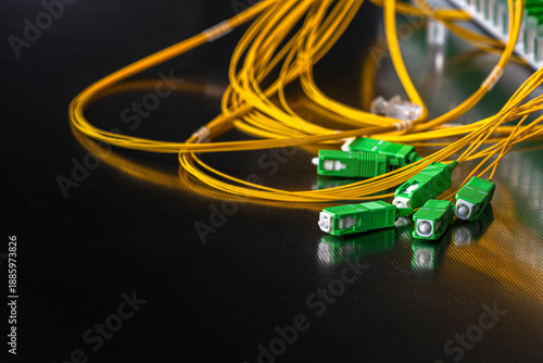 Optical fiber distribution panel with connected patch cords and SC APC connectors during installation in a passive fiber optic network.