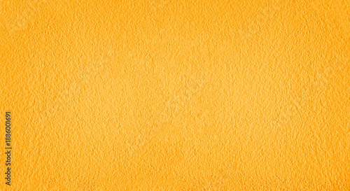 close up of a yellow painted wall with light streaks casting shadows across the textured surface