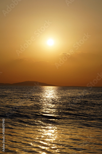 Beautiful fiery ocean sunset with red and orange glow on rippling sea surface