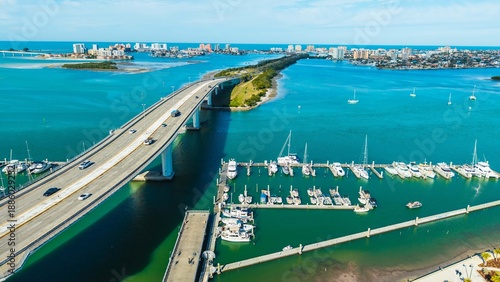 This drone shot over Coachman park, shows the Clearwater Marina and Memorial bridge & causeway leading to Clearwater Beach