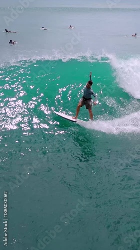 Aerial Surfer Riding Turquoise Wave, Carving Powerful Turn In Super Slow Motion Drone Shot With Spray,vertical video