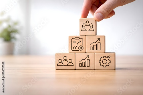 Change management process concept with hand arranging wooden blocks showing strategy, growth, learning, leadership, and teamwork icons, symbolizing organizational transformation, business improvement