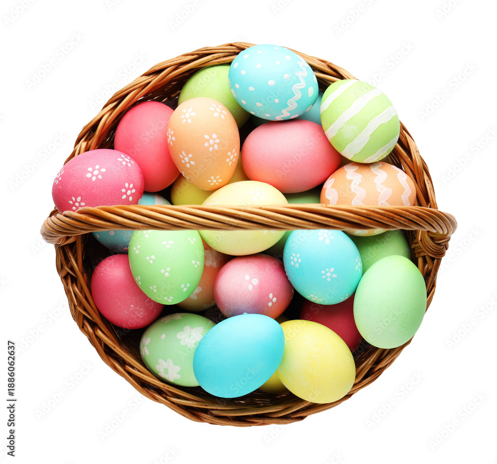 Naklejka premium Painted Easter eggs in wicker basket isolated on white, top view