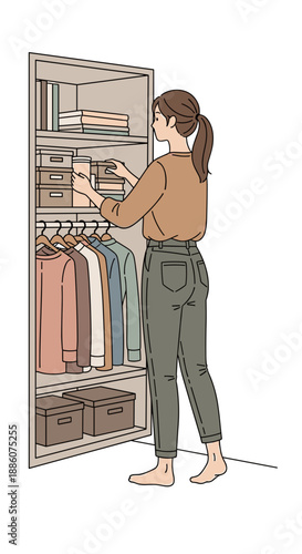 Woman organizing clothes and boxes in a modern wardrobe  