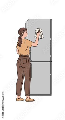 Young woman cleaning refrigerator with a cloth in kitchen  