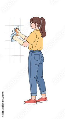 Young woman cleaning wall tiles with sponge in modern kitchen  