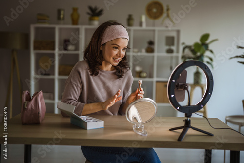 Bild auf Leinwand Woman v-logging beauty tutorial showing skincare routine using facial roller