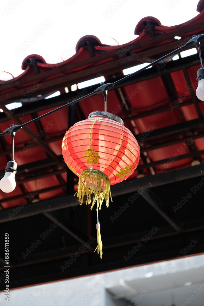 Φωτογραφία Traditional red Chinese lantern with golden tassels hanging outdoors under a til