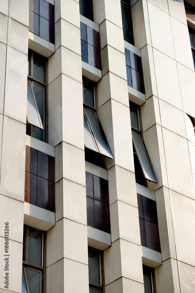 Fototapeta premium Modern building facade with repeating geometric patterns and open windows