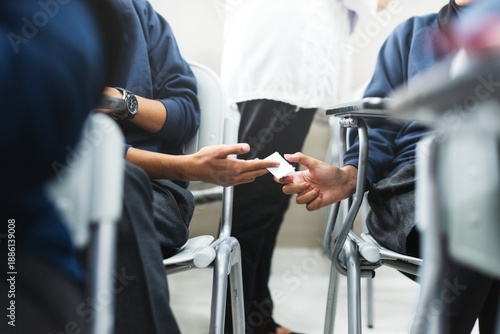 Foto Students discreetly passing notes in a classroom