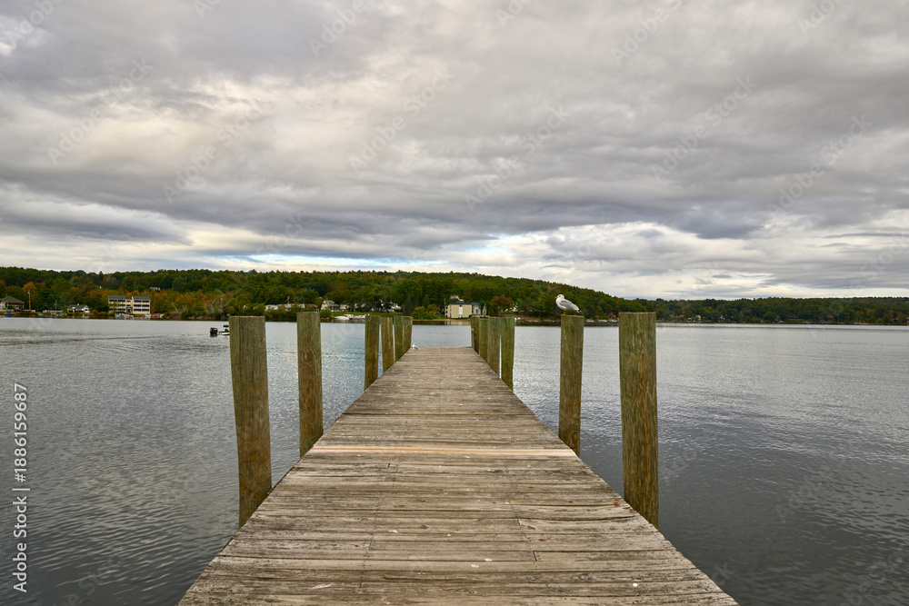 Naklejka premium Wooden Pier Leading Across Calm Lake Water in Minimal Landscape