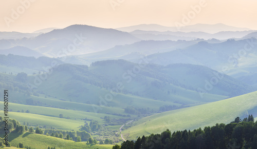 Ridge gradients in haze, view of the summer evening, hills and mountain slopes in sunset light