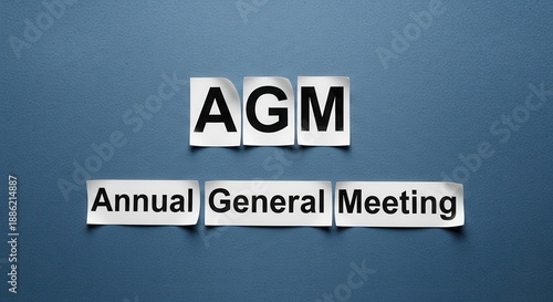 AGM - Annual General Meeting Concept on Blue Background.