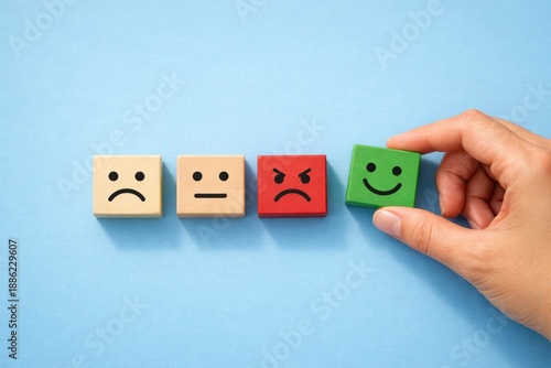 Mood Spectrum: Hand selects a green, smiling face block, highlighting emotional choices in a creative expression.