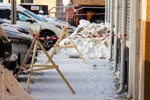 Wallpaper Mural Wooden sawhorses and caution tape cordon off an area beneath icicles danger on a snowy winter day Torontodigital.ca