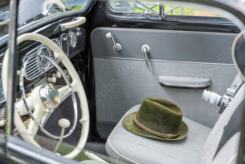 A vintage car with a green hat on the seat
