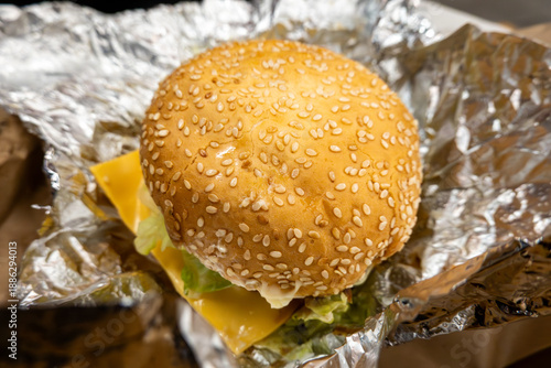 Stockholm, Sweden A large burger with a sesame bun in a foil wrapper.