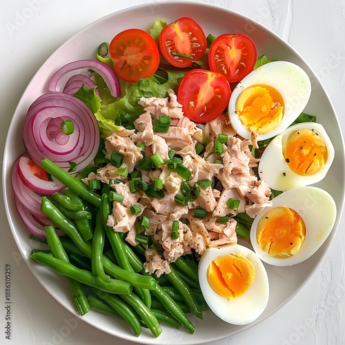 A colorful salad featuring shredded chicken, sliced tomatoes, boiled eggs, green beans,