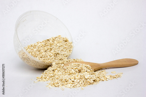 Raw oatmeal in the plastic bowl isolated on white background. Eating oatmeal regularly should benefit your health unless you have an oat or gluten allergy or sensitivity