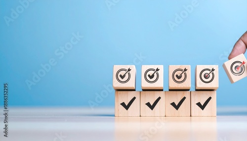 Goal achievement and business success concept with hand placing wooden block with target icon among check mark blocks on blue background for task management, strategy planning, and project milestone