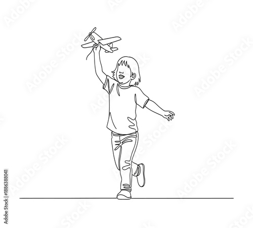 A child joyfully plays reaching for the sky while holding a paper airplane aloft